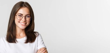 Gülümseyen, kendine güvenen, gözlüklü güzel esmer kız mutlu görünüyor..