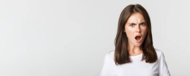 Öfkelenmiş, aşağılanmış, sinirli, somurtkan, beyaz bir geçmişi olan genç bir kadının yakın çekimi..