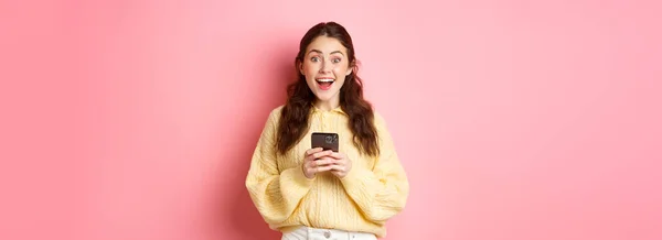 Retrato Menina Segurando Smartphone Olhando Surpreso Ofegante Animado Encontrou Algo — Fotografia de Stock