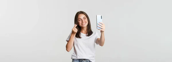 Šťastná Krásná Mladá Žena Ukazuje Srdeční Gesto Brát Selfie Smartphone — Stock fotografie