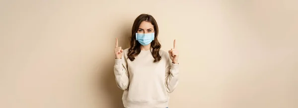 Happy Young Woman Medical Mask Covid Pointing Fingers Showing Promo — Stockfoto