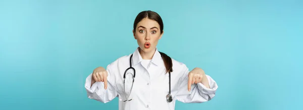 Enthusiastic Healthcare Worker Young Woman Doctor White Coat Pointing Fingers — Fotografia de Stock