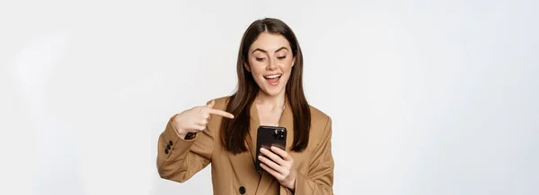 Entusiastisk Säljare Affärskvinna Pekar Finger Mobiltelefon Och Ler Visar Mobiltelefon — Stockfoto