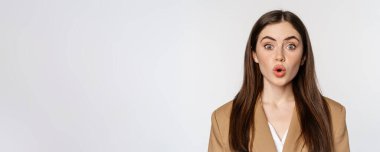 Close up portrait of surprised, amazed businesswoman, say wow, staring impressed at camera, fascinated face expression, white background.