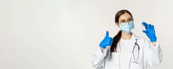 对年轻的专业女医生 戴医疗面罩和眼镜的医生的肖像进行拍照 展示疫苗并予以批准 推荐接种Covid 19疫苗 — 图库照片