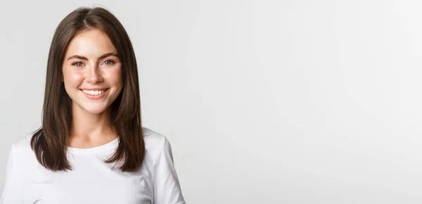 stock image Close-up of attractive brunette girl smiling happy, standing white background.