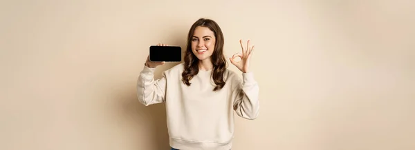 Smiling Happy Girl Showing Smartphone Screen App Mobile Interface Okay — Zdjęcie stockowe