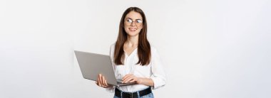 Genç ofis kadınının portresi, girişimci müşterileri laptopta cevaplıyor, mutlu yüzlü bilgisayarla çalışıyor, beyaz arka planda duruyor..