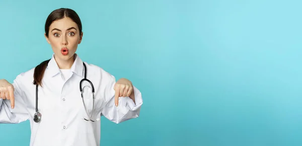 Enthusiastic Healthcare Worker Young Woman Doctor White Coat Pointing Fingers — Stockfoto