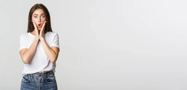 stock image Portrait of surprised and amused brunette girl looking wondered, gasping impressed.