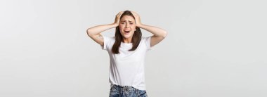 Sefil ve şok olmuş genç bir kız panikliyor, telaşlı görünüyor..