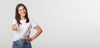 Gülümseyen, kendine güvenen genç kadın el sıkışmak için elini uzat, selamlayan kişi..