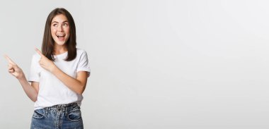 Çekici, gülümseyen esmer kız sol üst köşeyi işaret ediyor, logo gösteriyor..