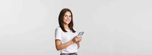 Atractiva Joven Morena Utilizando Teléfono Móvil Sonriendo Cámara —  Fotos de Stock