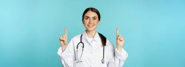 Lelkes Egészségügyi Dolgozó Fiatal Doktornő Fehér Köpenyben Sztetoszkóppal Hirdetést Mutat — Stock Fotó