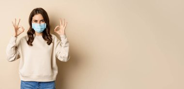 Covid-19, salgın ve karantina konsepti. Genç kadın Coronavirus omicron salgını sırasında tıbbi maske takıyor..