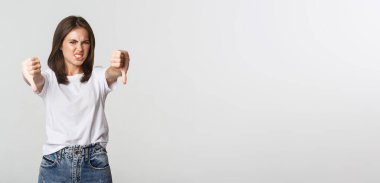 Tiksindirici esmer kız hoşlanmadığı için yüzünü buruşturuyor..