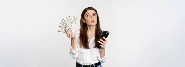 幸せな笑顔の女性の肖像携帯電話アプリを使用して 現金を保持し 白い背景の上に立っている スペースのコピー — ストック写真