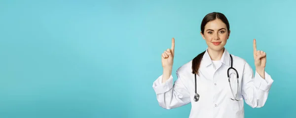 Portrait Confident Young Woman Doctor Medical Worker Coat Pointing Fingers — Stok fotoğraf
