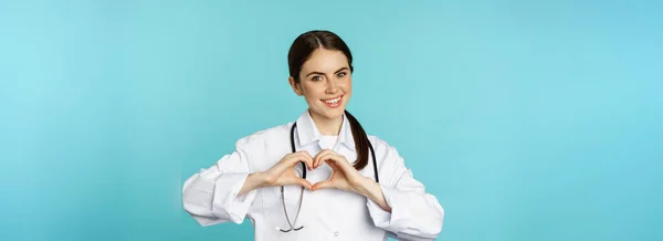 Young Doctor Woman Physician Showing Heart Love Sign Smiling Care —  Fotos de Stock