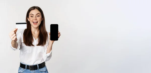 Glücklich Lachende Frau Zeigt Kreditkarte Handybildschirm Steht Vor Weißem Hintergrund — Stockfoto