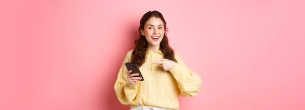 Jovem Mulher Atraente Segurando Smartphone Apontando Para Tela Promovendo Falando — Fotografia de Stock