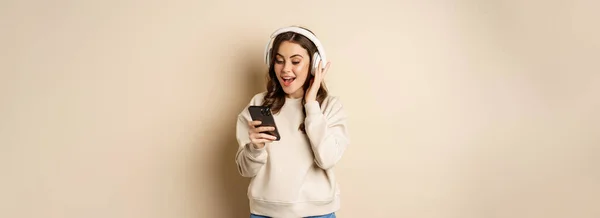 Smiling Happy Woman Listening Music Headphones Smartphone Laughing Excited Standing — Fotografia de Stock