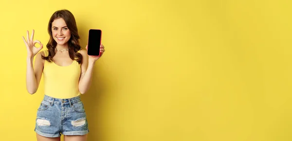 Pretty Brunette Woman Showing Mobile Phone Screen Smartphone App Interface — стоковое фото