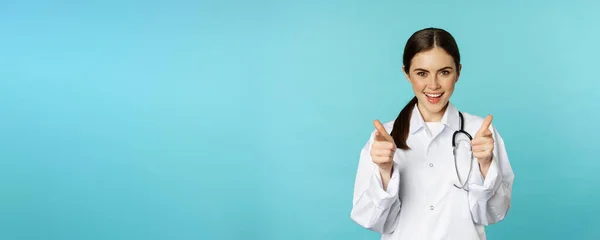 Enthusiastische Ärztin Lächelt Zeigt Mit Dem Finger Die Kamera Gratuliert — Stockfoto