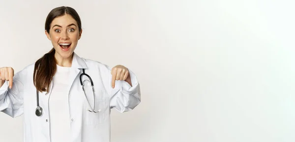 Portré Boldog Női Orvos Ujjal Lefelé Mosolyogva Bemutató Promo Ajánlat — Stock Fotó