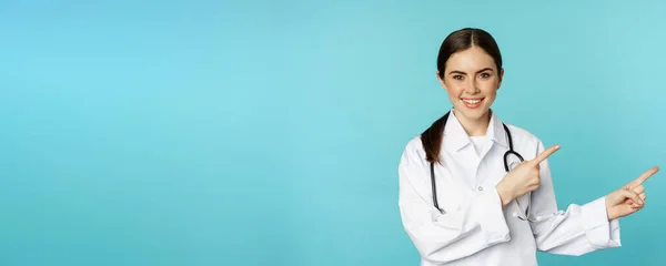 Portrét Mladého Profesionálního Lékaře Nemocniční Pracovnice Ukazující Prstem Doprava Zobrazující — Stock fotografie