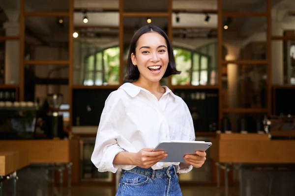 美しいウエイトレス デジタルタブレットを持つビジネスマン 笑って幸せそうに見える カフェやレストランの前に立って — ストック写真