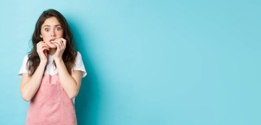 Tırnak yiyen korkmuş ve ürkmüş esmer bir kızın portresi. Şok olmuş ve endişeli bir şekilde kameraya bakıyor. Korkunç haberler duyuyor..