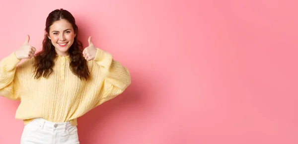 stock image Well done, very good. Smiling young woman showing thumbs up in approval, like your choice, praise good thing, standing satisfied against pink background.