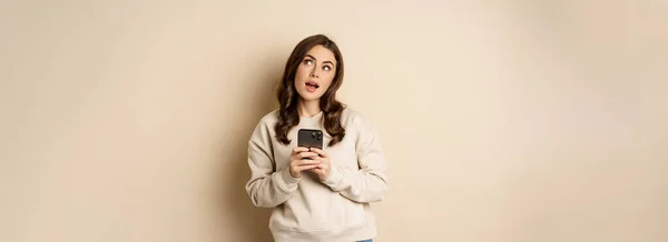 Online Shopping Nettes Mädchen Denkt Beim Halten Des Mobiltelefons Bildgebung — Stockfoto