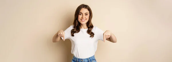 Uśmiechnięta Szczęśliwa Dziewczyna Wskazując Palcem Dół Pokazując Baner Logo Firmy — Zdjęcie stockowe