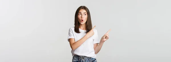 Opgewonden Aantrekkelijke Brunette Meisje Wit Shirt Wijzende Vingers Linksboven Zoek — Stockfoto