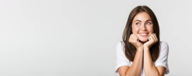 Sol üst köşeden bakan sevimli hayalperest kızın yakın çekimi. Nostaljik ve gülümseyen aptal..