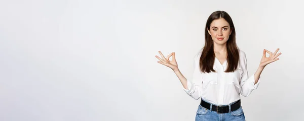 stock image Yoga and mindfulness. Young woman meditating with closed eyes, breathing freely and showing mudra nirvana sign, standing peaceful over white background.