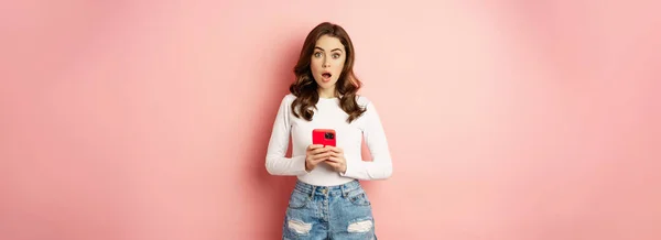 Surprised Woman Holding Pink Smartphone Gasping Amazed Looking Impressed Shocked — ストック写真