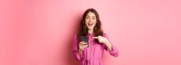 Młoda Kobieta Wskazująca Palcem Telefon Uśmiechnięta Mówiąca Aplikacji Smartfona Pokazująca — Zdjęcie stockowe