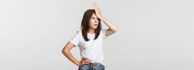 Rahatsız ve sinirli genç kadın facepalm ve yuvarlanan gözler.