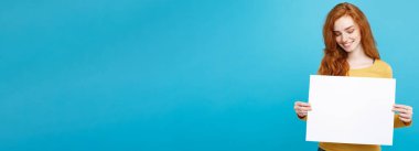 Boş işaret gösteren gülümseyen portre genç güzel çekici Kızıl kızıl saçlı kız kadar yakın. Mavi Pastel renkli. Kopya alanı