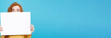 Boş işaret gösteren gülümseyen portre genç güzel çekici Kızıl kızıl saçlı kız kadar yakın. Mavi Pastel renkli. Kopya alanı