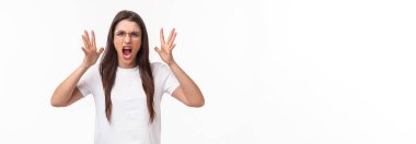 Waist-up portrait of angry, pissed-off brunette pretty girl in glasses, shouting, blaming partner for cheating on her, shaking hands and screaming, having confrontation, frowning aggressive.