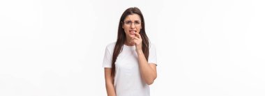 Utangaç genç kızın belden yukarı portresi gergin, şaşı ve ısıran dudaklar endişeli, birinin ne yaptığını fark etmesinden korkmuş, endişeli, beyaz arka planda paniklemiş..