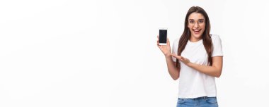 İletişim, teknoloji ve yaşam tarzı kavramı. Gözlüklü sevimli hippi kızın portresi, yeni başvuru formu, mobil uygulaması, internetten alışveriş merkezi yüklemesi, akıllı telefonu bekletmek..