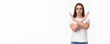 Kararlı, ciddi görünümlü genç kadın eylemcinin belden yukarı portresi, kadın zulmüne hayır diyor, dur hareketiyle çapraz işareti göster, kararlı görün, bir şeyi bırak, yasakla ya da onaylama.