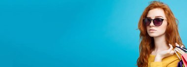 Alışveriş kavramı - portre genç güzel çekici Dişileştirilmiş kız kameraya alışveriş çantası ile seyir gülümseyen yakından. Mavi Pastel renkli. Kopya alanı