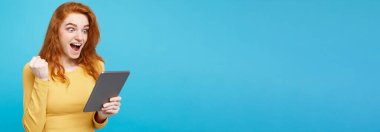 Portre genç güzel çekici Dişileştirilmiş kız dijital masada bir şey yeme içme ile gülümseyen mutlu kapatın. Mavi Pastel renkli. Kopya alanı.